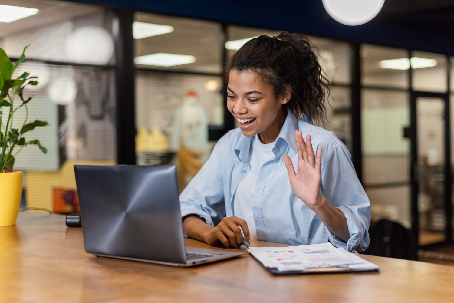 mulher sorridente fazendo uma videochamada no escritorio assistencia virtual